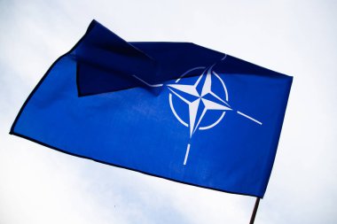 NATO (North Atlantic Treaty Organization) flag waving. NATO is an international military alliance that constitutes a system of collective security
