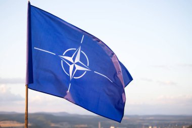 NATO (North Atlantic Treaty Organization) flag waving. NATO is an international military alliance that constitutes a system of collective security