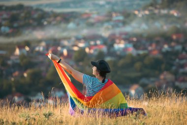 Woman holding a Gay Rainbow Flag. Happiness, freedom and love concept for same sex couples