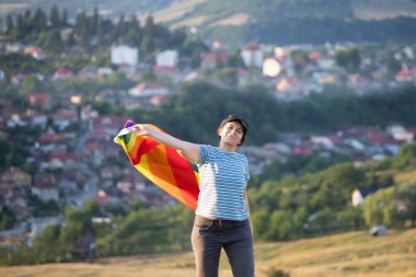 Woman holding a Gay Rainbow Flag. Happiness, freedom and love concept for same sex couples