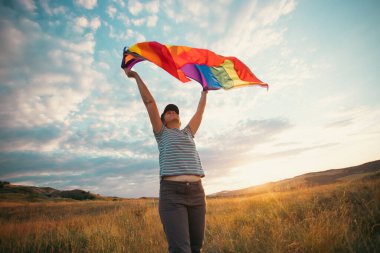 Eşcinsel Gökkuşağı Bayrağı Tutan Kadın. Aynı cinsiyetten çiftler için mutluluk, özgürlük ve aşk konsepti.