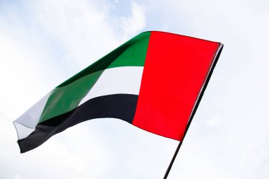 Birleşik Arap Emirlikleri bayrağı temiz ve sakin gökyüzüne karşı dalgalanıyor. BAE her yıl 2 Aralık 'ta ulusal günü kutluyor..