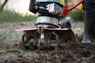 Çiftçi adam ekiciyle toprağı sürüyor toprağı ekime hazırlıyor..