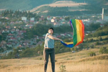 Woman holding a Gay Rainbow Flag. Happiness, freedom and love concept for same sex couples