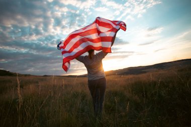 Amerikan bayrağı tutan genç bir kadın. Bağımsızlık Günü ya da Amerika 'da seyahat. 