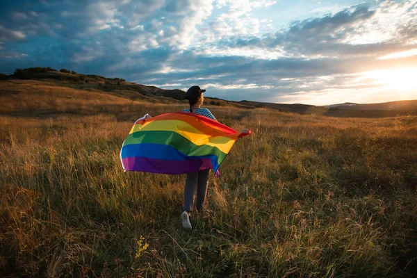 Woman holding a Gay Rainbow Flag. Happiness, freedom and love concept for same sex couples