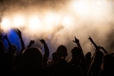 Konserde kalabalık - Parlak renkli sahne ışıkları önünde tezahürat yapan kalabalık