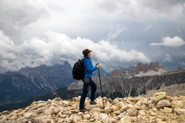 İtalya 'nın Cinque Torri yakınlarındaki Dolomite Alpleri manzarasının tadını çıkaran sırt çantalı bir kadın yürüyüşçü. Aktif insanlar ve dağ konsepti.