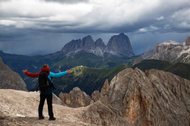 Genç adam fırtınalı bir yaz gününde Marmolada dağında Dolomitler 'de yürüyüş yapıyor..