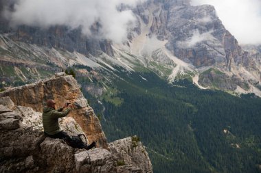 Tepede sırt çantalı bir yürüyüşçü Cinque Torri, İtalya yakınlarındaki Dolomite Alpleri manzarasının tadını çıkarıyor. Aktif insanlar ve dağ konsepti.