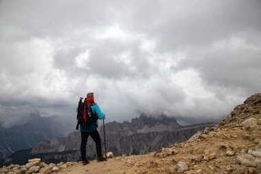 İtalya 'nın Rifugio Nuvolau yakınlarındaki Dolomite Alpleri manzarasının tadını çıkaran sırt çantalı bir adam. Aktif insanlar ve dağ konsepti.