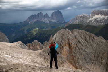 Genç adam fırtınalı bir yaz gününde Marmolada dağında Dolomitler 'de yürüyüş yapıyor..