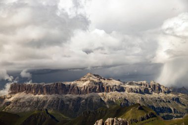 İtalya 'nın güneyindeki Marmolada' dan gelen İtalyan Dolomite 'ları dramatik fırtınalı gökyüzü ve sisli Sella grubunun panoramik görüntüsü.