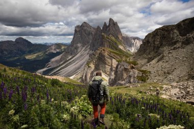 Genç adam bir yaz günü Seceda dağında Dolomitlerde (İtalya) yürüyüş yapıyor..