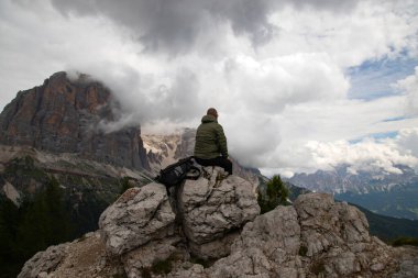 Tepede sırt çantalı bir yürüyüşçü Cinque Torri, İtalya yakınlarındaki Dolomite Alpleri manzarasının tadını çıkarıyor. Aktif insanlar ve dağ konsepti.