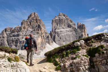 Dolomites, İtalya 'da Tre Cime di Lavaredo' nun etkileyici zirvelerinin çarpıcı güzelliğine hayran kalan bir yürüyüşçü..