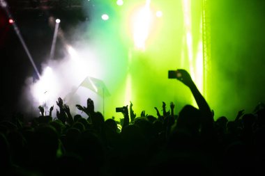 Konserde kalabalık - Parlak renkli sahne ışıkları önünde tezahürat yapan kalabalık