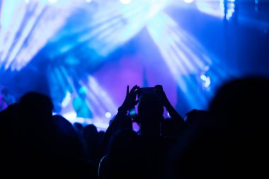 Konserde kalabalık - Parlak renkli sahne ışıkları önünde tezahürat yapan kalabalık