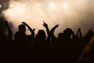 Konserde kalabalık - Parlak renkli sahne ışıkları önünde tezahürat yapan kalabalık