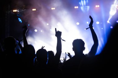 Konserde kalabalık - Parlak renkli sahne ışıkları önünde tezahürat yapan kalabalık