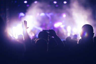 Konserde kalabalık - Parlak renkli sahne ışıkları önünde tezahürat yapan kalabalık