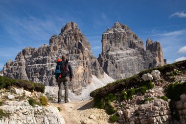 Dolomites, İtalya 'da Tre Cime di Lavaredo' nun etkileyici zirvelerinin çarpıcı güzelliğine hayran kalan bir yürüyüşçü..