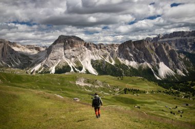 Genç adam bir yaz günü Seceda dağında Dolomitlerde (İtalya) yürüyüş yapıyor..