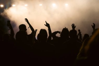 Konserde kalabalık - Parlak renkli sahne ışıkları önünde tezahürat yapan kalabalık