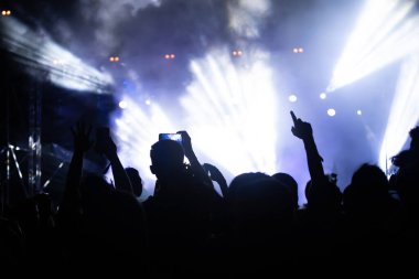 Konserde kalabalık - Parlak renkli sahne ışıkları önünde tezahürat yapan kalabalık