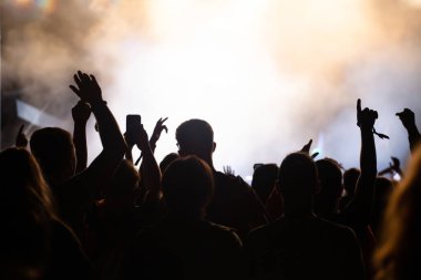 Konserde kalabalık - Parlak renkli sahne ışıkları önünde tezahürat yapan kalabalık