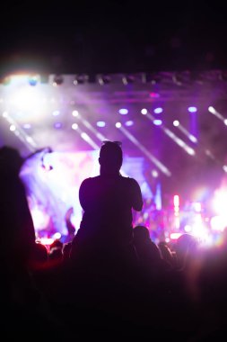 Konserde kalabalık - Parlak renkli sahne ışıkları önünde tezahürat yapan kalabalık