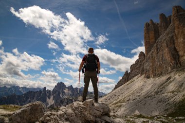 Dolomites, İtalya 'da Tre Cime di Lavaredo' nun etkileyici zirvelerinin çarpıcı güzelliğine hayran kalan bir yürüyüşçü..