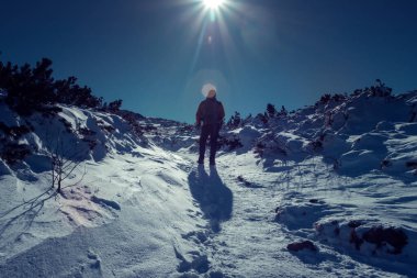 Karla kaplı dağda yürüyen bir adam. Doğadaki aktif insanlar, macera konsepti. 