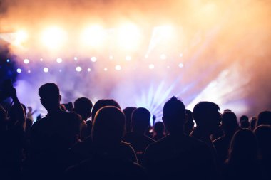 Konserde kalabalık - Parlak renkli sahne ışıkları önünde tezahürat yapan kalabalık