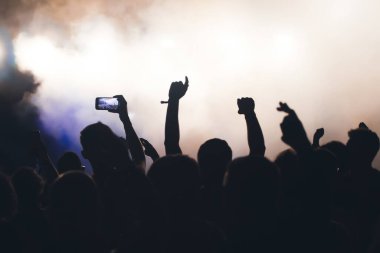 Konserde kalabalık - Parlak renkli sahne ışıkları önünde tezahürat yapan kalabalık