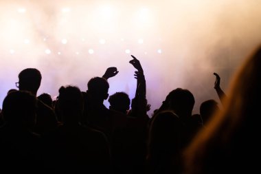 Konserde kalabalık - Parlak renkli sahne ışıkları önünde tezahürat yapan kalabalık