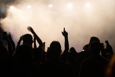 Konserde kalabalık - Parlak renkli sahne ışıkları önünde tezahürat yapan kalabalık