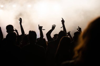 Konserde kalabalık - Parlak renkli sahne ışıkları önünde tezahürat yapan kalabalık