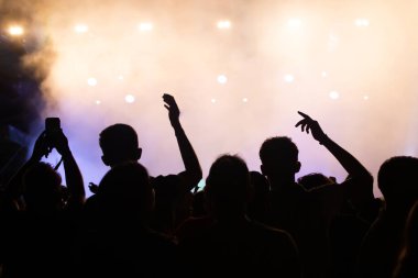 Konserde kalabalık - Parlak renkli sahne ışıkları önünde tezahürat yapan kalabalık