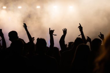 Konserde kalabalık - Parlak renkli sahne ışıkları önünde tezahürat yapan kalabalık