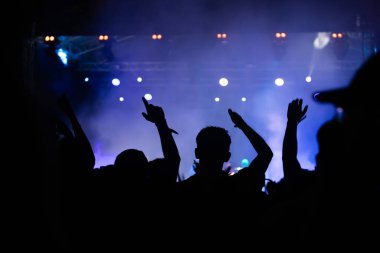 Konserde kalabalık - Parlak renkli sahne ışıkları önünde tezahürat yapan kalabalık