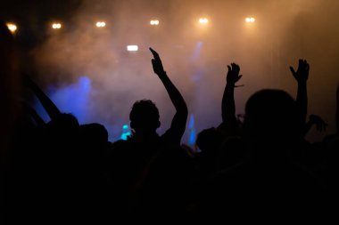 Konserde kalabalık - Parlak renkli sahne ışıkları önünde tezahürat yapan kalabalık