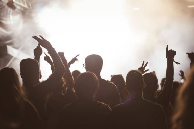 Konserde kalabalık - Parlak renkli sahne ışıkları önünde tezahürat yapan kalabalık