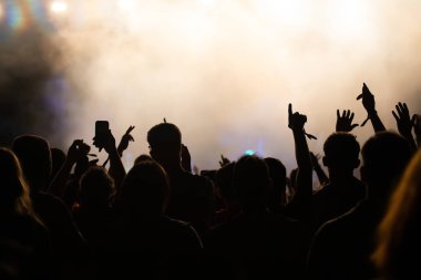 Konserde kalabalık - Parlak renkli sahne ışıkları önünde tezahürat yapan kalabalık