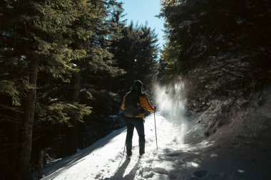 Karla kaplı dağda yürüyen bir adam. Doğadaki aktif insanlar, macera konsepti. 