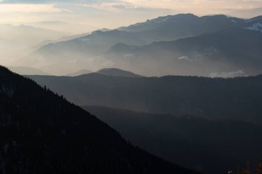 Romanya 'nın Ceahlau dağındaki sihirli günbatımında kış manzarası.