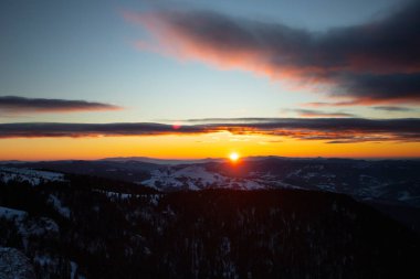 Romanya 'nın Ceahlau dağındaki sihirli günbatımında kış manzarası.