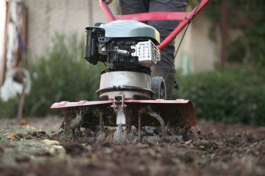 Çiftçi adam ekiciyle toprağı sürüyor toprağı ekime hazırlıyor..