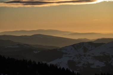 Romanya 'nın Ceahlau dağındaki sihirli günbatımında kış manzarası.
