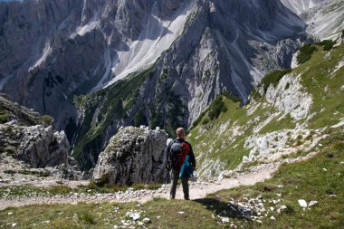 Dolomitler, İtalya 'da, Tre Cime di Levaredo' nun bir parçası olan Cadini di Misurina dağ grubunun etkileyici sivri tepelerinin büyüleyici güzelliğine hayran kalan bir adam yürüyüşçüsü..